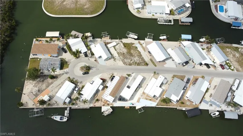 Aerial view of property and surrounding area with a nearby body of water and nearby suburban area