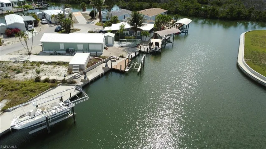 Dock with a water view, boat lift, and a residential view