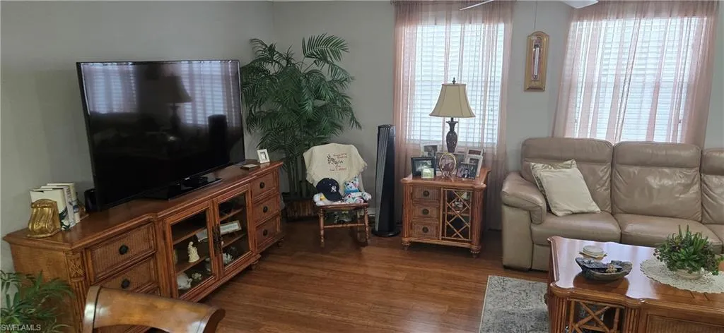 Living area with wood finished floors and ceiling fan