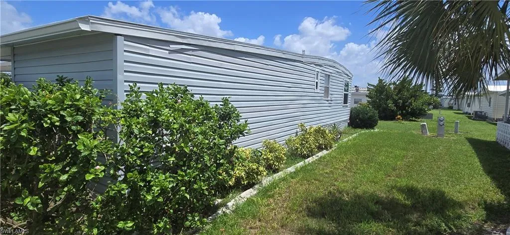 View of side of home with a yard