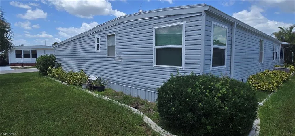 View of side of property with a lawn