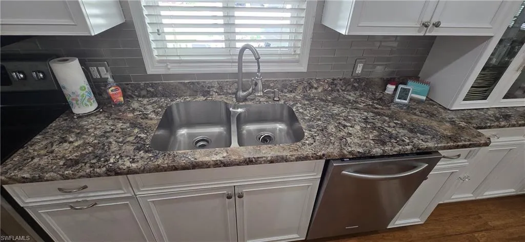 Kitchen with dishwasher and white cabinetry