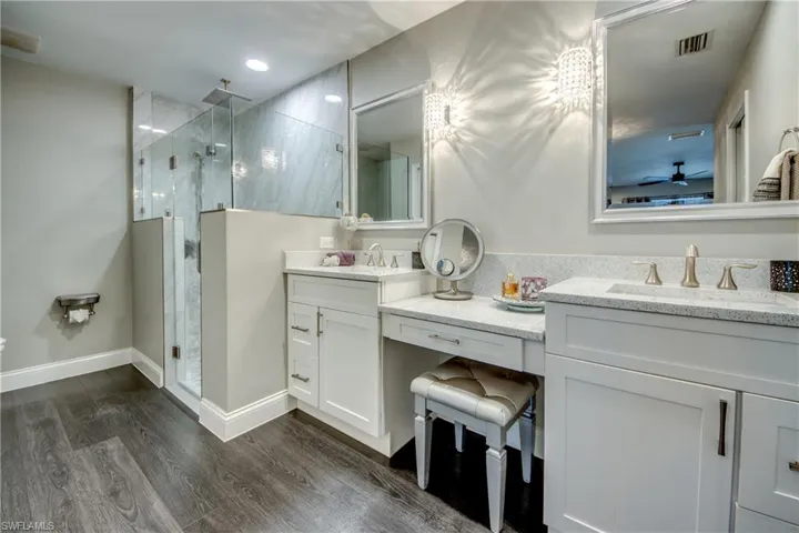 Glass-enclosed shower with tiled walls and a rain shower head