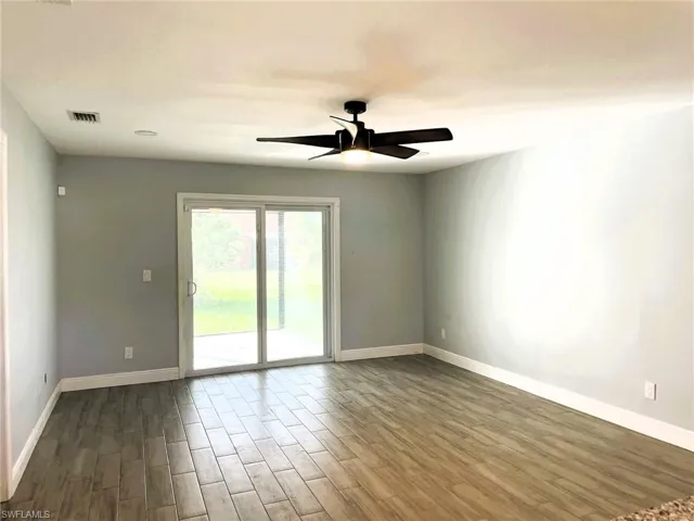 Spare room with wood finish floors and ceiling fan