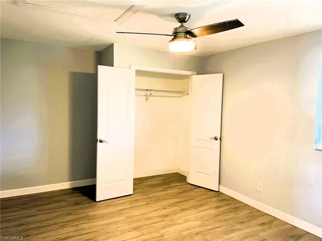 Unfurnished bedroom with light wood-style flooring, ceiling fan, and a closet