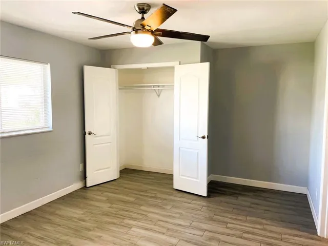 Unfurnished bedroom with light wood finished floors, ceiling fan, and a closet