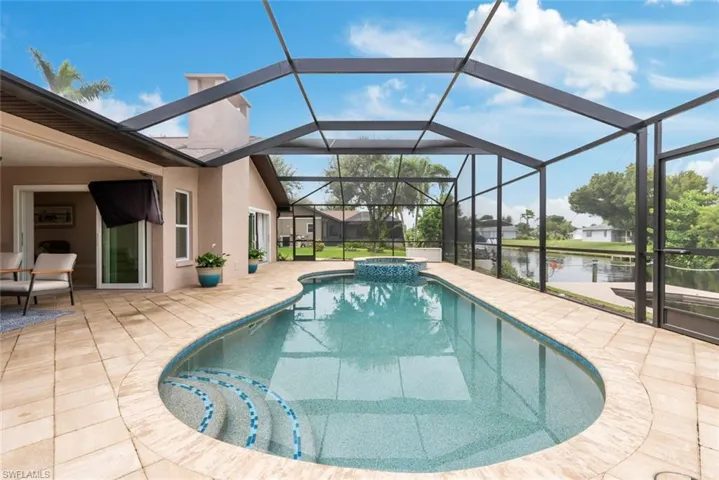 View of pool with a lanai, a water view, and a patio area