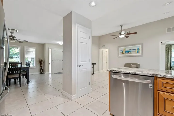 Kitchen with ceiling fan, light tile patterned floors, and stainless steel dishwasher