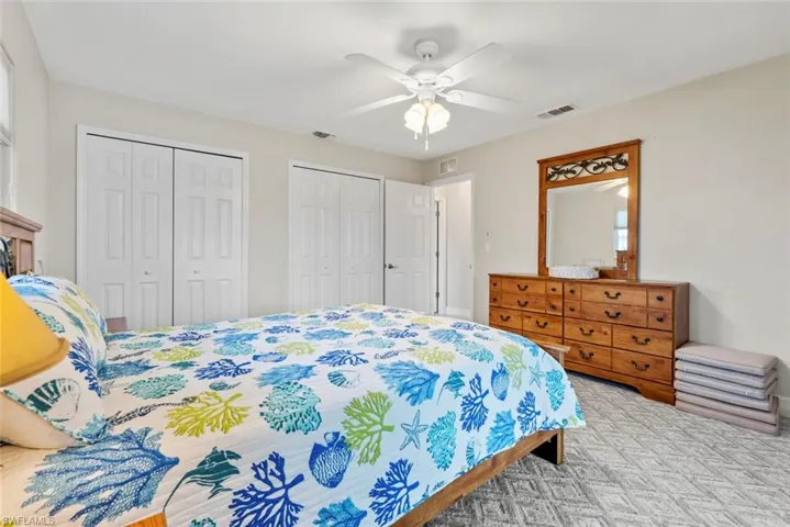 Bedroom featuring ceiling fan and two closets