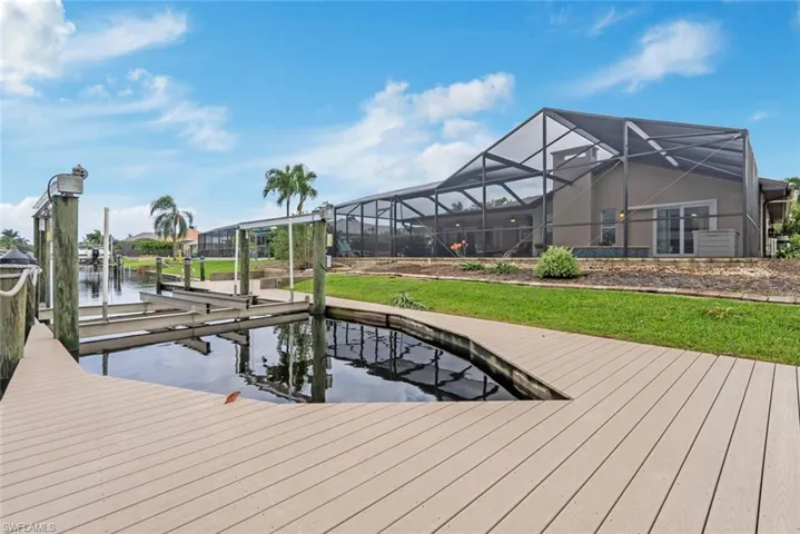 View of dock with a lanai and a water view