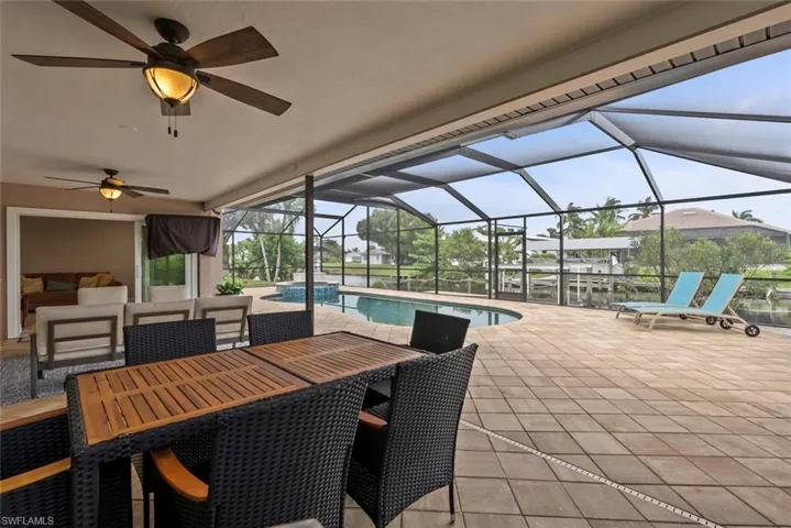 View of patio featuring ceiling fan, an outdoor living space, and glass enclosure