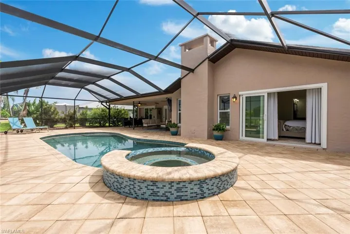 View of swimming pool featuring an in ground hot tub, a lanai, and a patio area