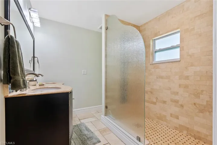 Bathroom with vanity and tiled shower
