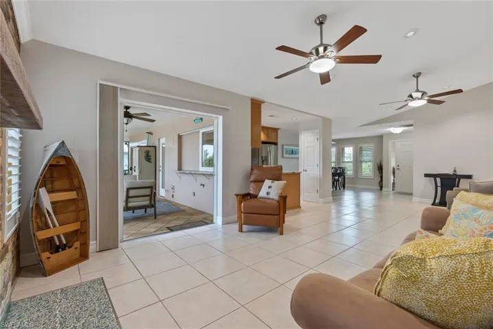 Living room with ceiling fan and light tile patterned floors