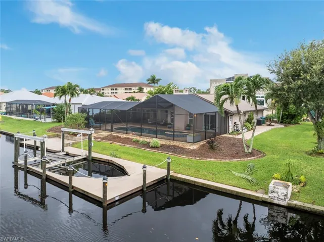 Dock area featuring a lanai, a water view, a pool, and a lawn