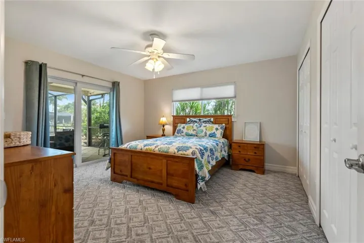 Bedroom featuring access to outside, a closet, multiple windows, and ceiling fan