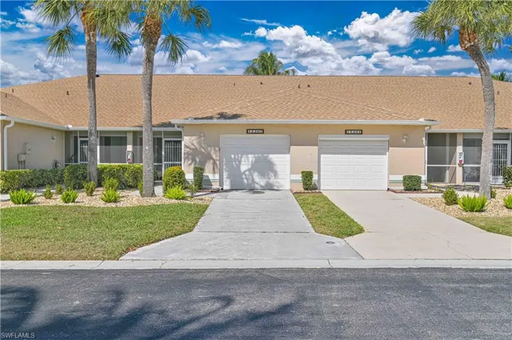 Single story home with concrete driveway, stucco siding, a garage, and a front lawn