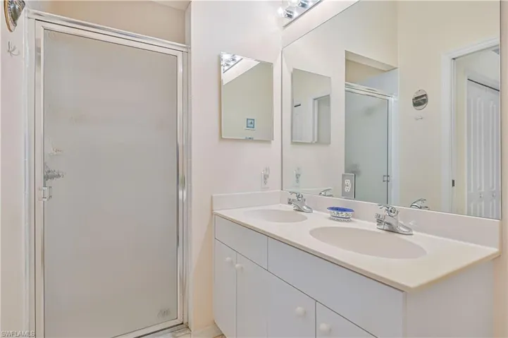 Bathroom with double vanity and a shower stall