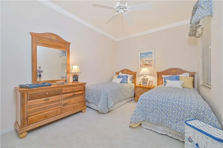 Bedroom with carpet flooring, ornamental molding, and a ceiling fan