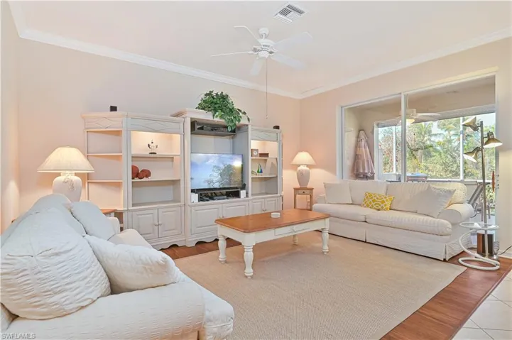 Living area with crown molding, ceiling fan, and light wood-style floors