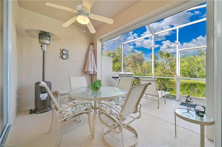 Sunroom / solarium featuring outdoor dining space, a ceiling fan, and a patio