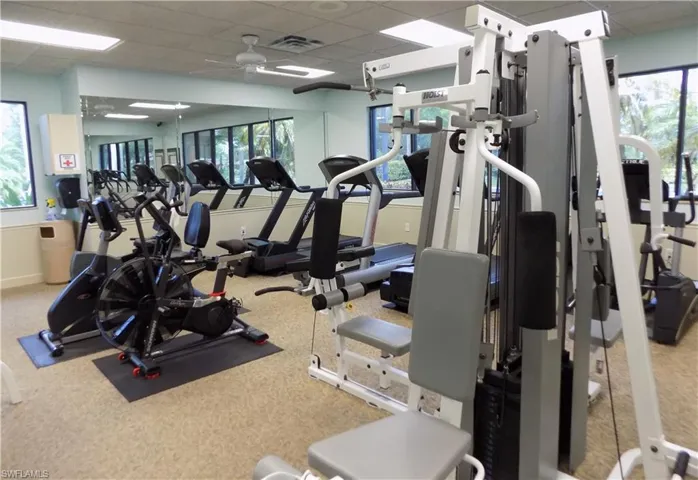 Gym with a paneled ceiling and a ceiling fan