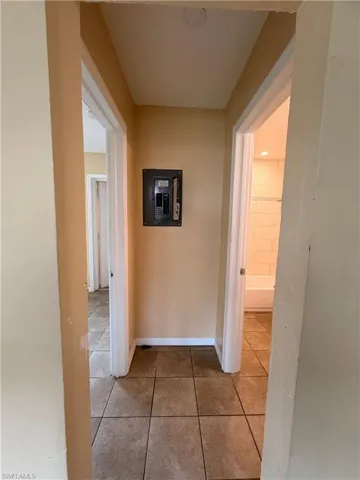 Hall featuring light tile patterned floors and electric panel
