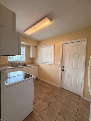 Laundry room featuring baseboards and light tile patterned floors