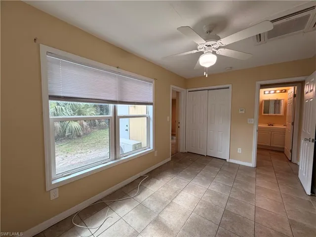 Unfurnished bedroom featuring light tile patterned floors, ceiling fan, and a closet