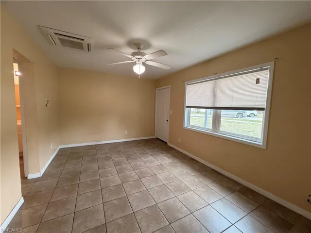 Unfurnished room with ceiling fan and light tile patterned flooring