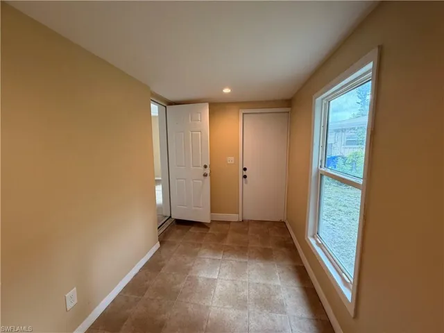 Doorway to outside featuring baseboards and recessed lighting