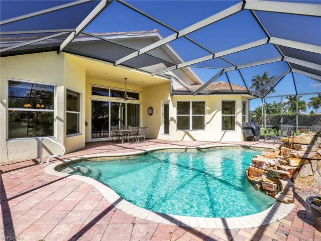 Swimming pool featuring a sunroom, a lanai, a patio area, grilling area, and outdoor dining area