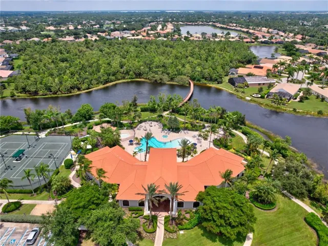 Drone / aerial view of a pool area and a nearby body of water