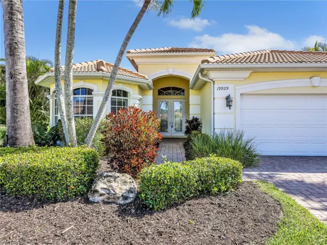 Mediterranean / spanish house featuring french doors, an attached garage, stucco siding, and a tiled roof