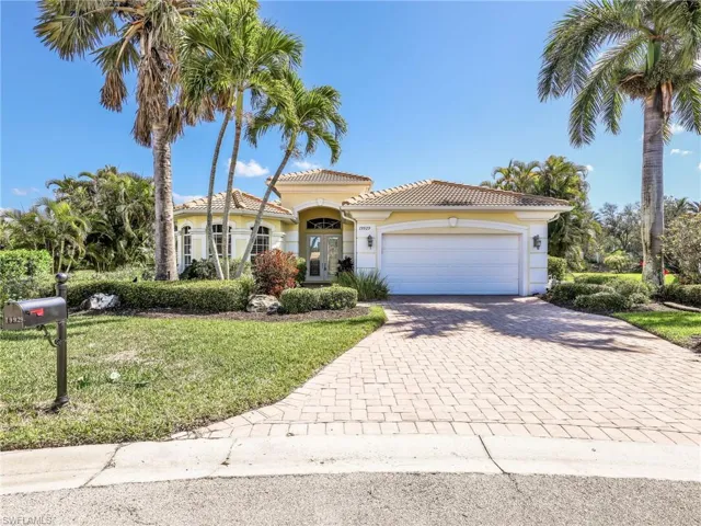Mediterranean / spanish-style home featuring decorative driveway, an attached garage, a front yard, stucco siding, and a tile roof