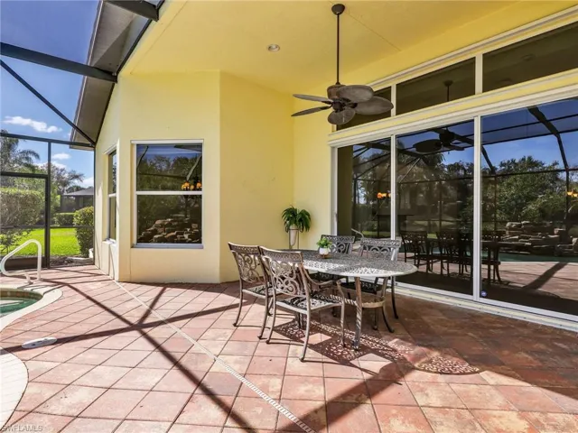 View of patio with a sunroom, a lanai, outdoor dining area, and an outdoor pool