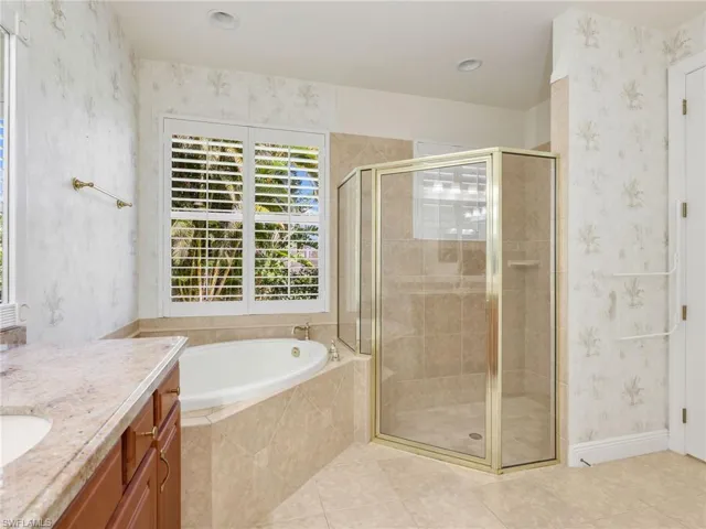 Bathroom featuring wallpapered walls, vanity, a shower stall, a bath, and light tile patterned floors