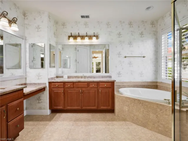 Full bath with vanity, a bath, wallpapered walls, healthy amount of natural light, and light tile patterned floors