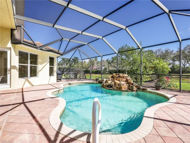 Swimming pool with a sunroom, a patio, and glass enclosure