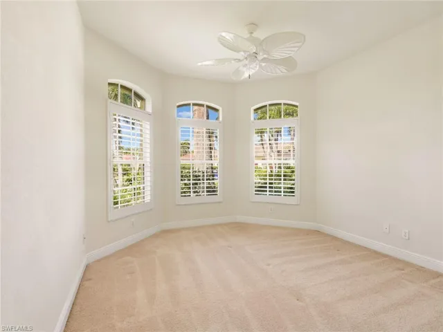 Unfurnished room featuring light carpet, plenty of natural light, and ceiling fan