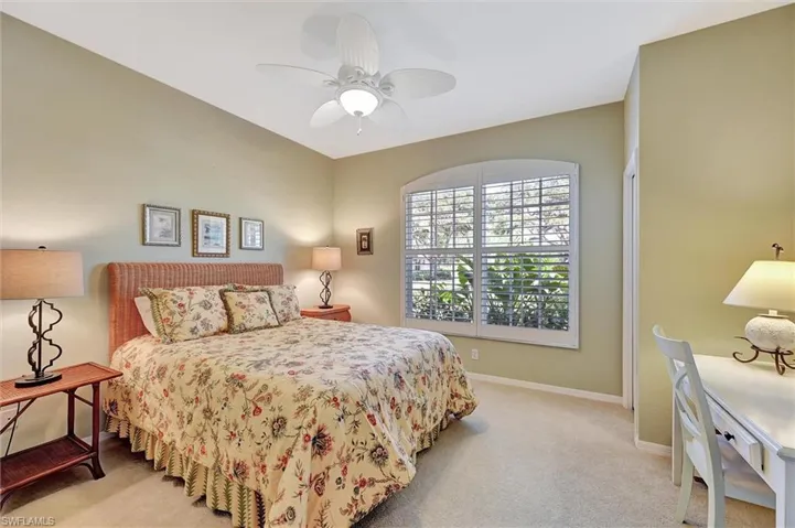 Bedroom with baseboards, ceiling fan, and light colored carpet