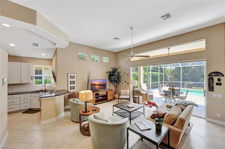 Living area featuring visible vents, baseboards, light tile patterned flooring, and ceiling fan
