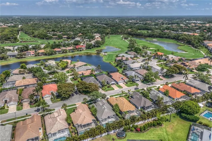 Drone / aerial view with a residential view, golf course view, and a water view