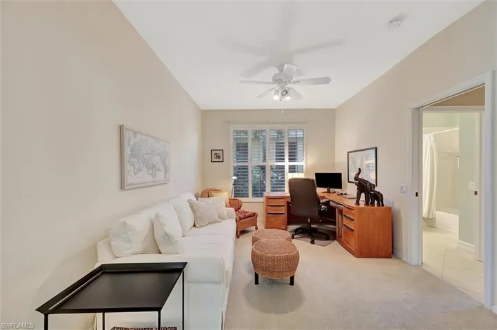 Carpeted office space featuring a ceiling fan