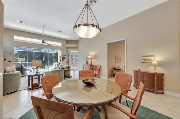 Dining space with light tile patterned floors, baseboards, and visible vents
