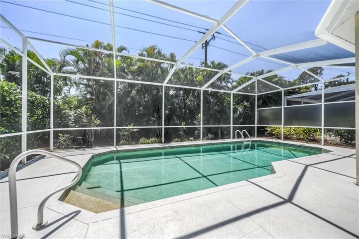 Pool with glass enclosure and a patio