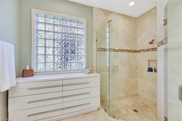 Full bath featuring a wealth of natural light and a shower stall