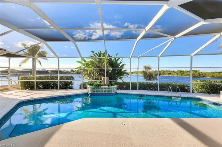 Outdoor pool with a sunroom, a lanai, and a water view