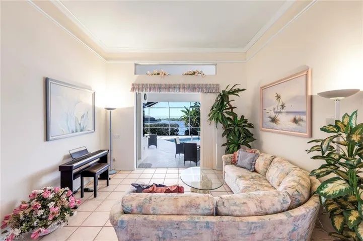 Living area with light tile patterned flooring and crown molding
