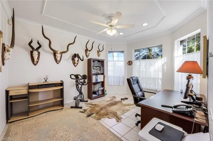 Office area featuring a ceiling fan, light tile patterned floors, and ornamental molding